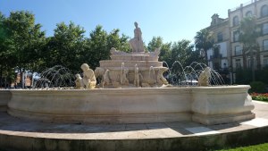 Photo of a fountain, lined with sculptures of cherubs, with a centrepiece of a seated man